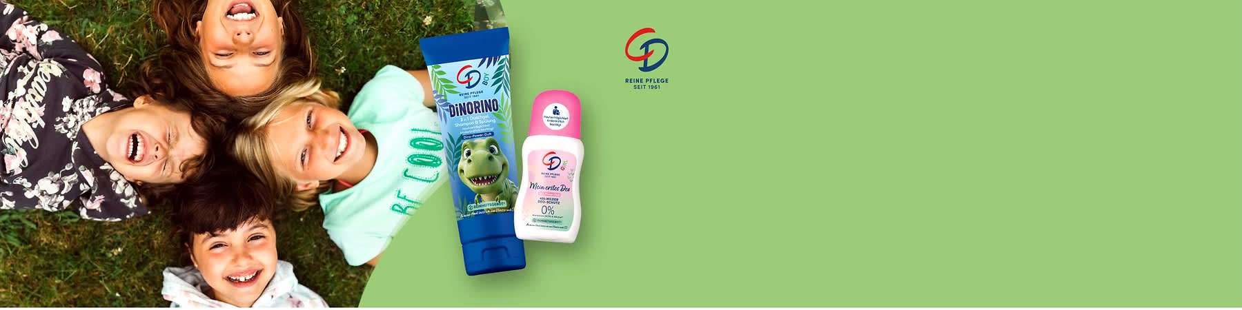 zwei Kinderpflegeprodukte der Marke CD auf hellgrünem Hintergrund: links eine blaue Tube mit Dino-Illustration und Aufschrift „DiNORINO 3 in 1 Duschgel, Shampoo & Spülung“, rechts ein weißer Deo-Roller mit rosa Kappe und Aufschrift „Mein erstes Deo 48h milder Deo-Schutz 0% Aluminium & Alkohol“ und Markenlogo