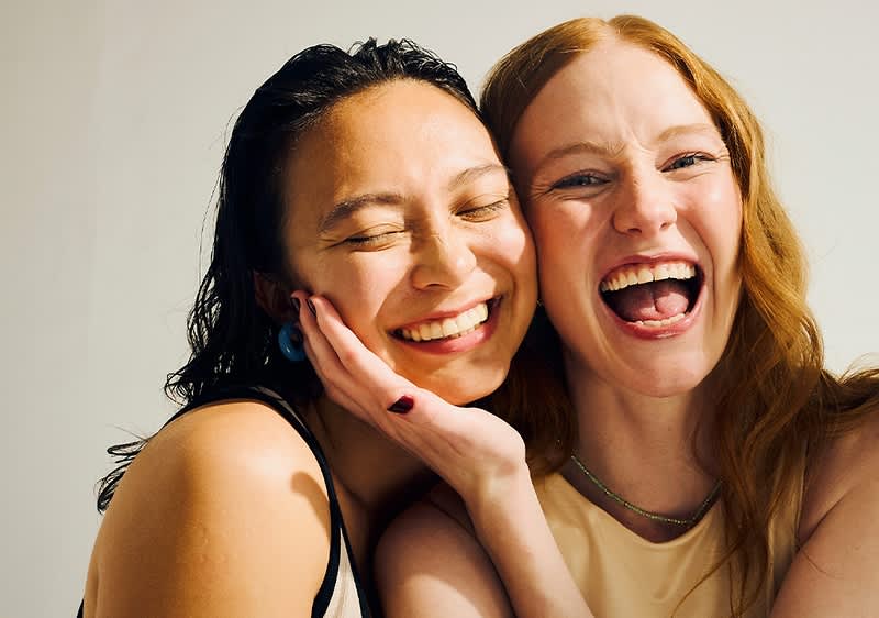 Zwei Frauen lachen und umarmen sich