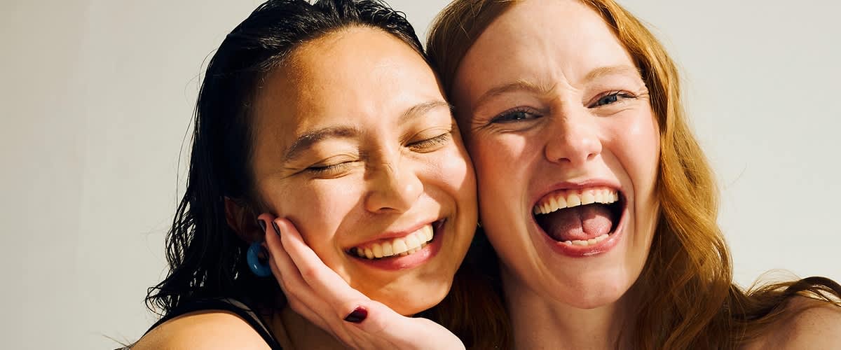 Zwei Frauen lachen und umarmen sich