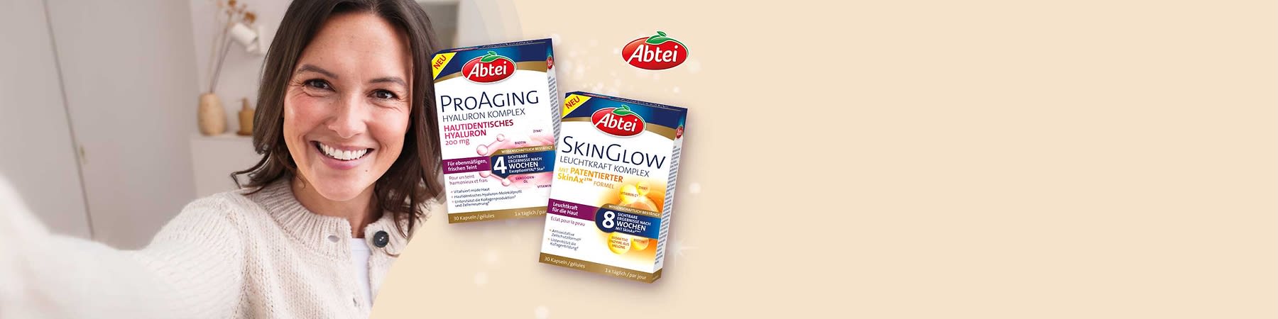Frau mit unscharf gemachtem Gesicht hält Hand vor Brust, rechts zwei Packungen Abtei Nahrungsergänzung: links blau-weiße Packung „Abtei ProAging Hyaluron Komplex 200 mg“, rechts gelb-blau-weiße Packung „Abtei SkinGlow Leuchtkraft Komplex 8 Wochen“ und oben rechts rotes Abtei-Logo
