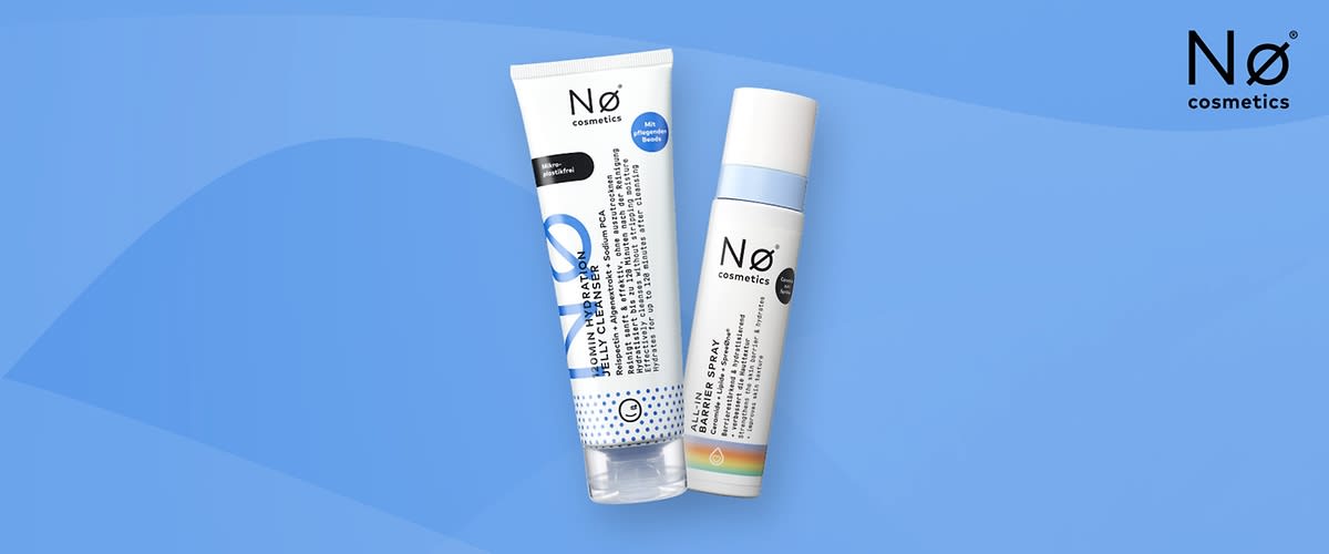 Zwei Kosmetikprodukte der Marke „Nø cosmetics“ vor blauem Hintergrund: links eine weiße Tube mit blauer Schrift und Aufdruck „Nø cosmetics“ und rechts eine weiße Sprühflasche mit hellblauem Deckel und Markenaufdruck
