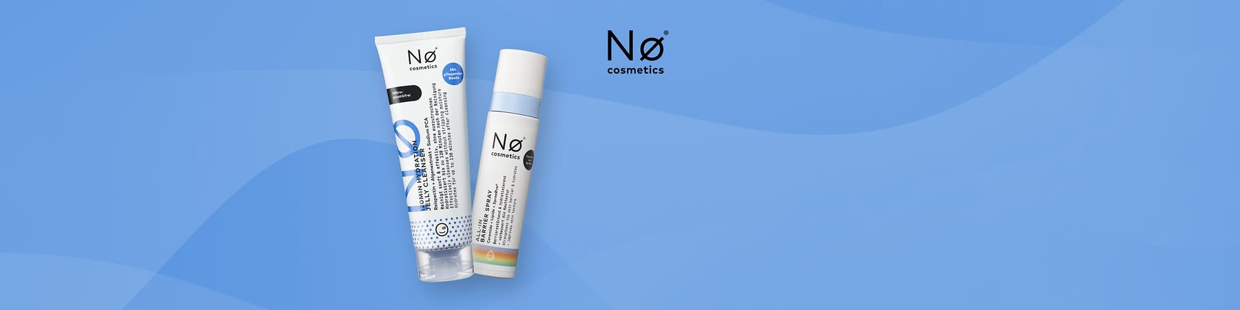 Zwei Nø cosmetics Produkte auf blauem Hintergrund: links eine weiße Tube mit blauer Grafik und der Aufschrift „Mildly Cleansing“ bzw. „Salicylic Cleanser“, rechts eine weiße Spraydose mit blauem Schriftzug und Aufdruck „Bakteriell Barrier Spray“ sowie kleines Regenbogenband unten, rechts oben das Nø cosmetics Logo