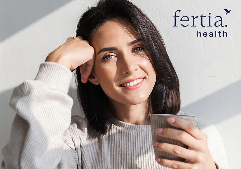 Frau mit Tasse in der Hand lächelt