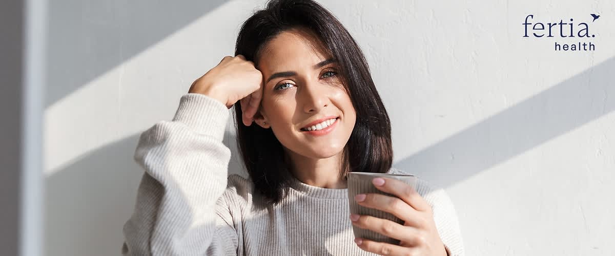 Frau mit Tasse in der Hand lächelt