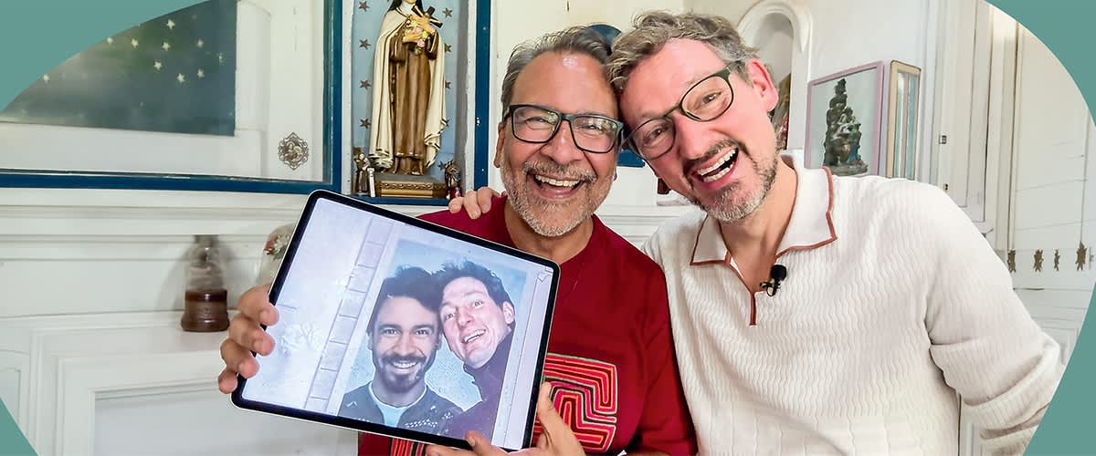 Eckart von Hirschhausen und sein Freund Adriano sitzen nebeneinander, Adriano hält ein Tablet mit einem Foto von Ihnen.