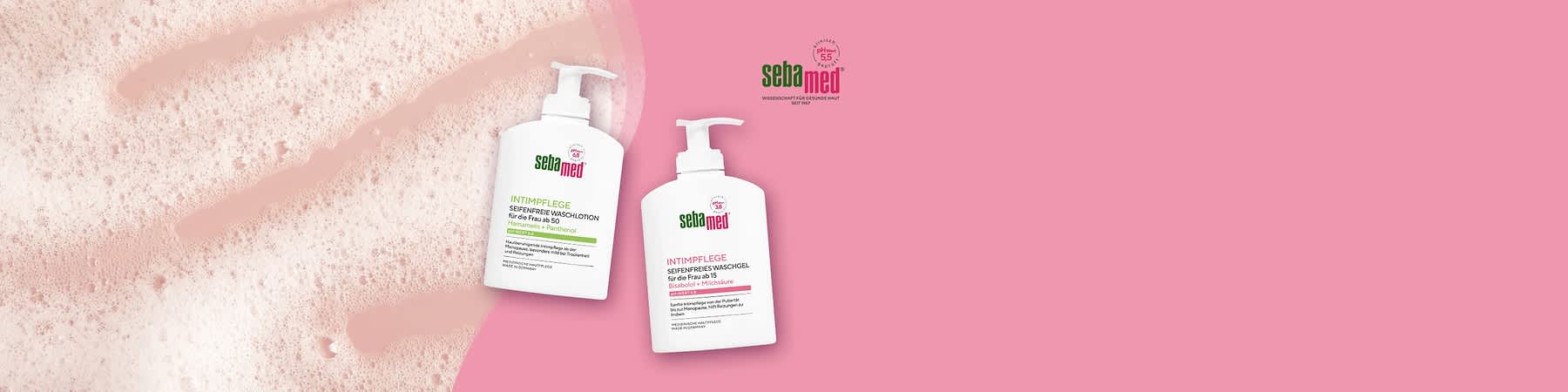 Zwei weiße Pumpflaschen Sebamed Intimpflege Seifenfreies Waschgel, links Variante für die Frau ab 60 mit Hamamelis + Panthenol, rechts Variante für die Frau ab 15 mit Bisabolol + Milchsäure, Hintergrund rosa und Schaumreste links sichtbar