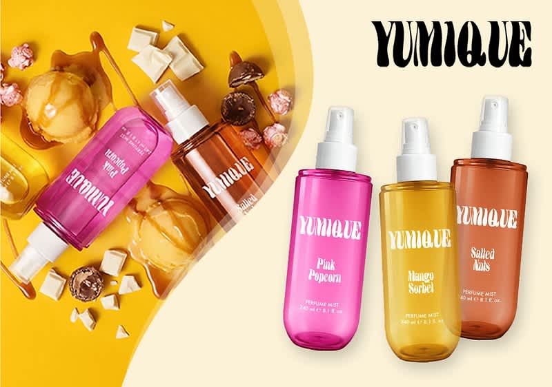 Drei Duftsprays der Marke YUMIQUE in transparenten Kunststoffflaschen mit Sprühkopf: links pink beschriftet „Pink Popcorn“, mittig gelb beschriftet „Mango Sorbet“, rechts orange-braun beschriftet „Salted Nuts“; links daneben eine Anordnung von Kugeln, Karamell, Schokolade und weißer Schokolade auf gelbem Hintergrund