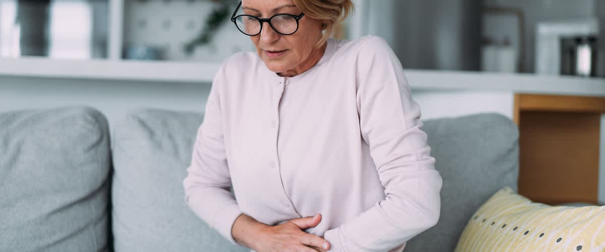 Frau legt ihre Hände auf den Unterbauch
