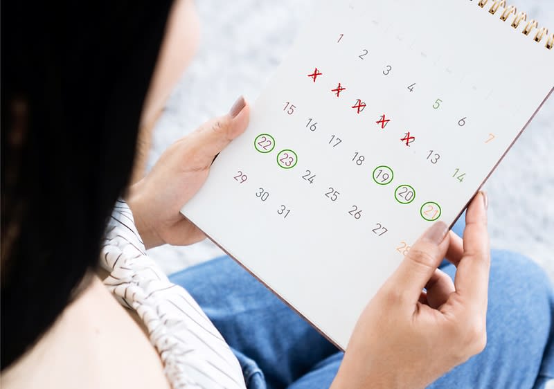 Frau schaut auf Zykluskalender