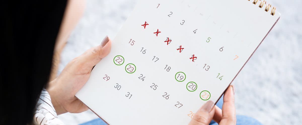 Frau schaut auf Zykluskalender