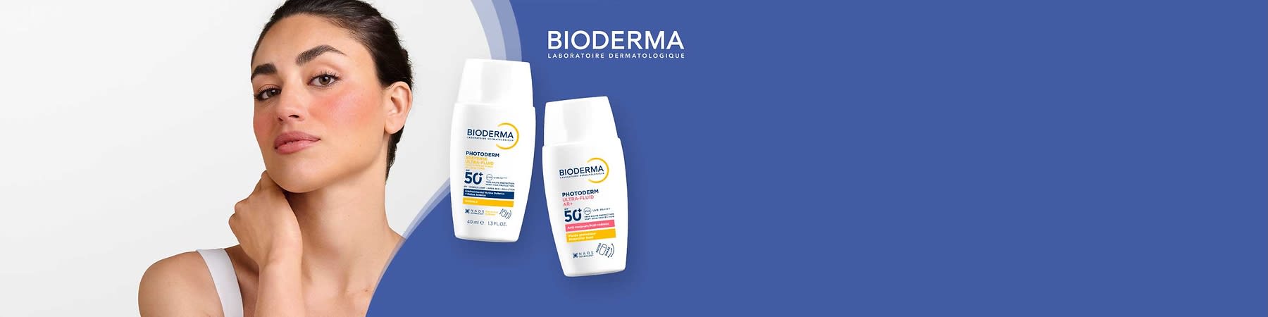 Zwei weiße Bioderma Photoderm Sonnenschutzflaschen auf blauem Hintergrund, rechte Flasche beschriftet „Photoderm Ultra-Fluid AR+ LSF 50+“, linke Flasche „Photoderm Ultra-Fluid LSF 50+“, Markenlogo oben rechts