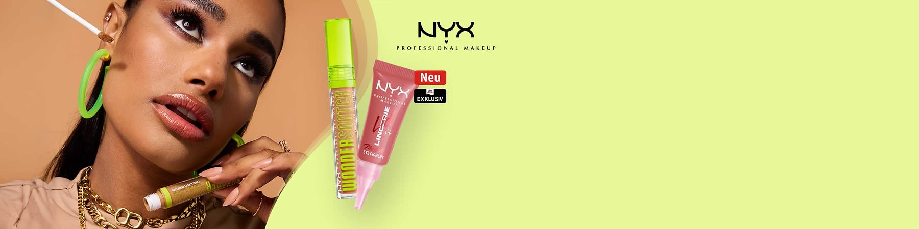 Nahaufnahme einer Frau mit auffälligem Make-up und grünen Creolen; daneben zwei NYX-Produktverpackungen: links eine grüne Mascara-Röhre mit Aufschrift „WONDERSTICK“, rechts ein rosafarbenes Tuben-Eye-Pigment mit Marke „NYX PROFESSIONAL MAKEUP“ und roten Stickern „Neu“ und „Exklusiv“