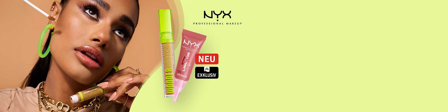Nahaufnahme einer Frau mit auffälligem Make-up und grünen Creolen; daneben zwei NYX-Produktverpackungen: links eine grüne Mascara-Röhre mit Aufschrift „WONDERSTICK“, rechts ein rosafarbenes Tuben-Eye-Pigment mit Marke „NYX PROFESSIONAL MAKEUP“ und roten Stickern „Neu“ und „Exklusiv“