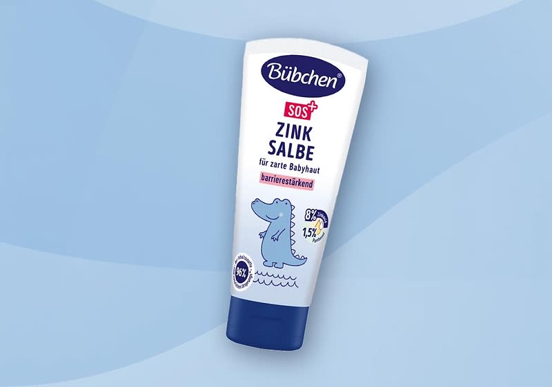 Bübchen SOS Zinksalbe in weißer Tube mit blauem Verschluss, Text „für zarte Babyhaut“ und illustrierter blauer Dino auf hellblauem Hintergrund