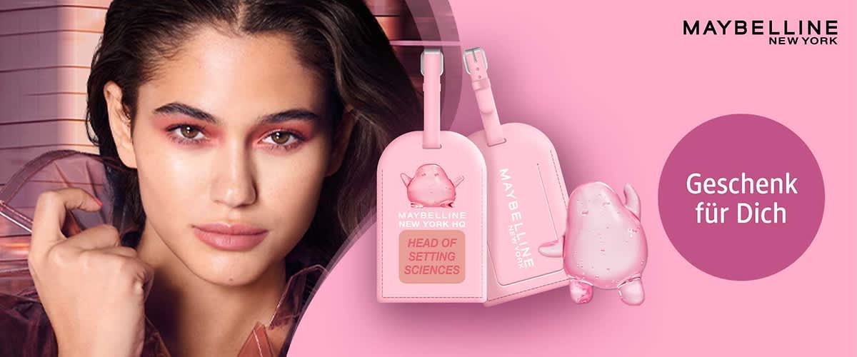 Rosafarbene Reisetaschen-Anhänger mit Maybelline New York-Branding, dazu eine kleine rosafarbene Comic-Figur und ein violetter Kreis mit dem weißen Text „Geschenk für Dich“