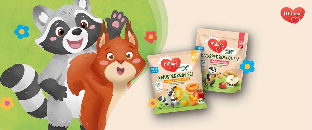 Zwei Milupa Produktverpackungen mit Knusperringen und Knusperböllchen. Links eine Packung mit der Aufschrift „Knusperkringel Banane & Karotte-Citrus“, rechts „Knusperböllchen Apfel-Erdbeere“. Beide Verpackungen zeigen bunte Illustrationen von Obst und Tieren. Oben rechts das Milupa-Logo.