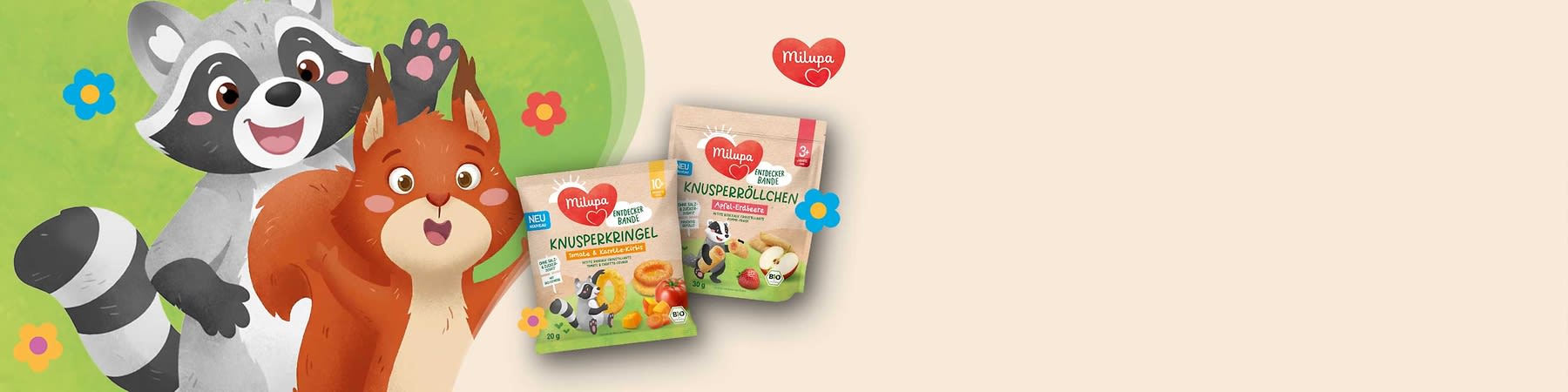 Zwei Milupa-Verpackungen für Kinder-Snacks. Links Knusperkringel mit Tomate und Karotte, rechts Knusperbällchen mit Apfel und Erdbeere. Beide Verpackungen zeigen bunte Blumen und ein Tiermotiv. Oben rechts das Milupa-Logo in Herzform.