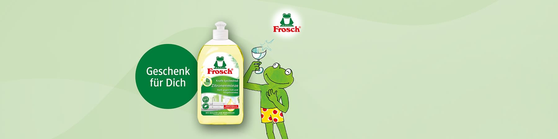 Flasche Spül-Gel von Marke Frosch mit Aufschrift „Zitronenminze“, daneben grüner Kreis mit Text „Geschenk für Dich“ und rechts die gezeichnete Froschfigur mit Glas in der Hand