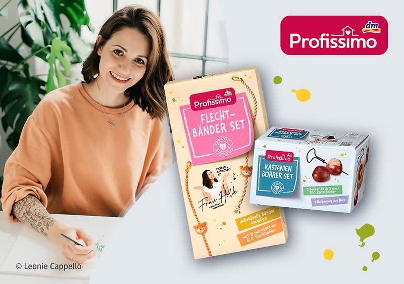 Frau sitzt lächelnd am Tisch und zeichnet Blumen, daneben zwei Profissimo Bastelsets in Verpackung: ein „Flechtbänder Set“ und ein „Kastanien Bohrer Set“ mit dm-Profissimo-Logo