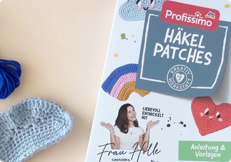 Packungsfront von Profissimo „Häkel Patches“ mit Anleitung, bunten gehäkelten Motiven und Foto einer Frau, links daneben hellblau gehäkeltes Herz und blaues Knäuel Garn