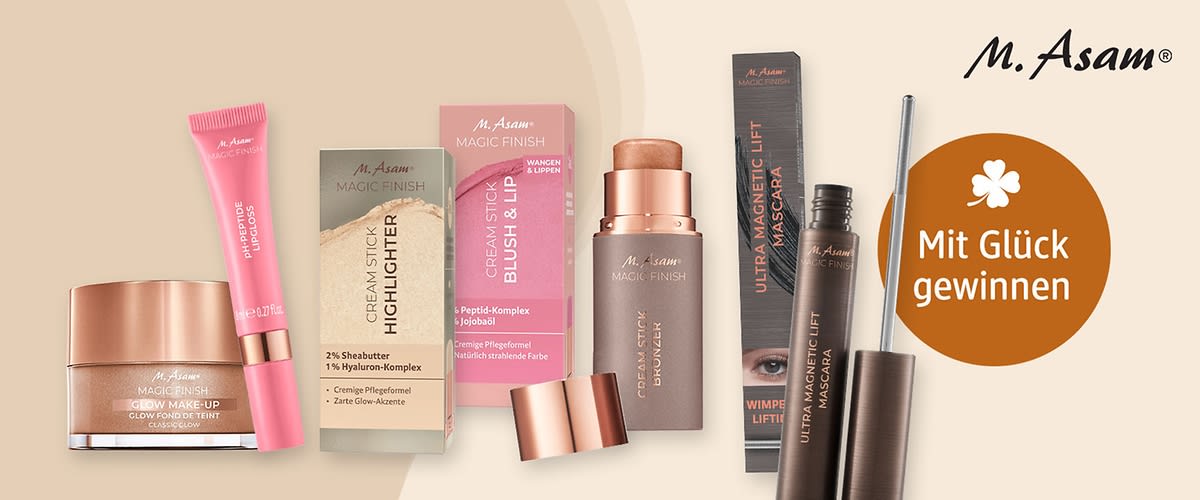 Mehrere M. Asam Magic Finish Kosmetikprodukte nebeneinander: links ein rosa Lipgloss-Röhrchen mit goldener Kappe und der Aufschrift „PH-Peptide Lipgloss“, daneben ein champagnerfarbener Cream Stick Bronzer mit abnehmbarem Deckel, mittig eine schwarze Verpackung mit der Aufschrift „Ultra Magnetic Lift Mascara“ und einem Augenbild, rechts eine geöffnete braune Mascara mit silberner Bürste; oben rechts das M. Asam Logo und ein orangefarbener Kreis mit der weißen Aufschrift „Mit Glück gewinnen“
