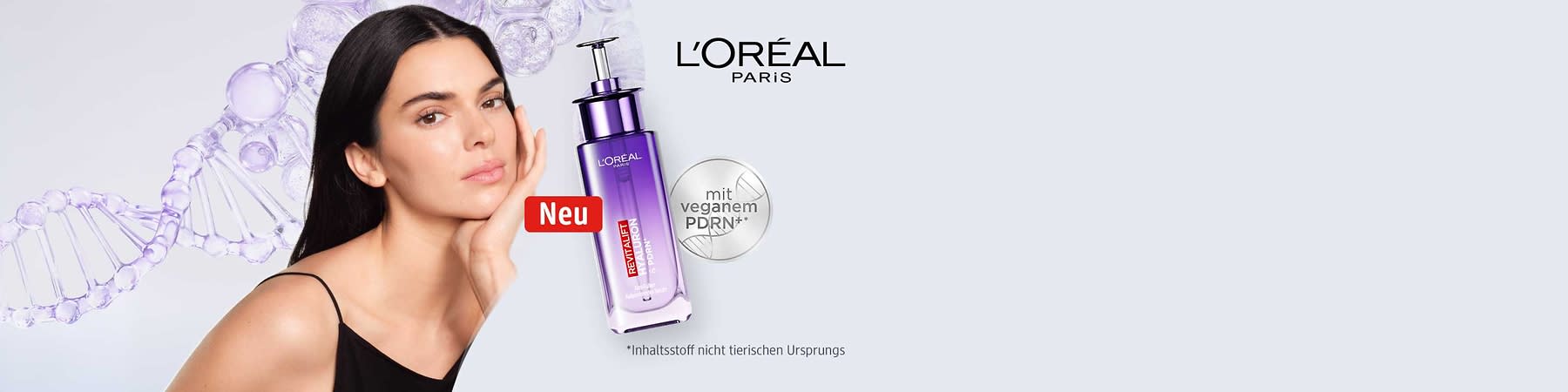 Frau mit dunklen Haaren und nackten Schultern neben einer violetten L’Oréal-Paris-Pumpflasche mit Aufschrift „Revitalift“, roter Button „Neu“ und silbernem Kreis mit Text „mit veganem PDRN*“ plus Fußnotehinweis zu Inhaltsstoffen nicht tierischen Ursprungs