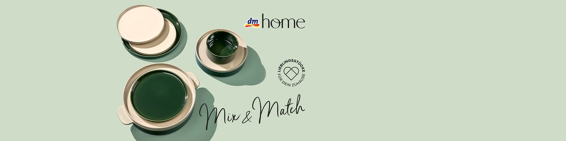 Mehrere grün- und cremefarbene Keramik-Teller und eine Tasse auf pastellgrünem Hintergrund, Schriftzug Mix & Match und dm home Logo sowie rundes Siegel Lieblingsstücke für dein Zuhause