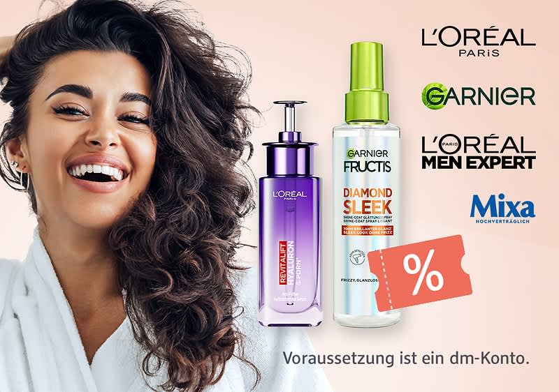 Lachende Frau mit locker gelocktem dunklem Haar und weißem Bademantel links, daneben zwei Haarpflegeflaschen (lila L’Oréal Revitalift Pumpflasche, transparente Garnier Fructis Diamond Sleek Sprühflasche mit grünem Sprühkopf), rechts Markenlogos L’Oréal Paris, Garnier, L’Oréal Men Expert und Mixa sowie Rabatt-Symbol und Schriftzug „Voraussetzung ist ein dm-Konto“