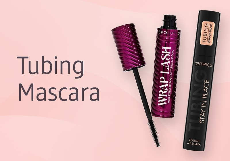 Zwei Tubing-Mascaras nebeneinander auf rosa Hintergrund, links geöffnete lila Tube mit abgezogenem Bürstenstab und Aufschrift „WRAP LASH“, rechts schwarze Tube mit Aufschrift „CATRICE STAY IN PLACE TUBING VOLUME MASCARA“ und links daneben großer Text „Tubing Mascara“