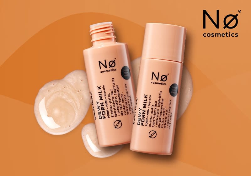 Zwei pastellrosa Kunststoff-Flaschen der Marke „Nø cosmetics“ mit schwarzer Aufschrift „DEWI MILK PDRN“ liegend, daneben zwei Produktspender aus cremigem Serum und oben rechts das Nø cosmetics-Logo