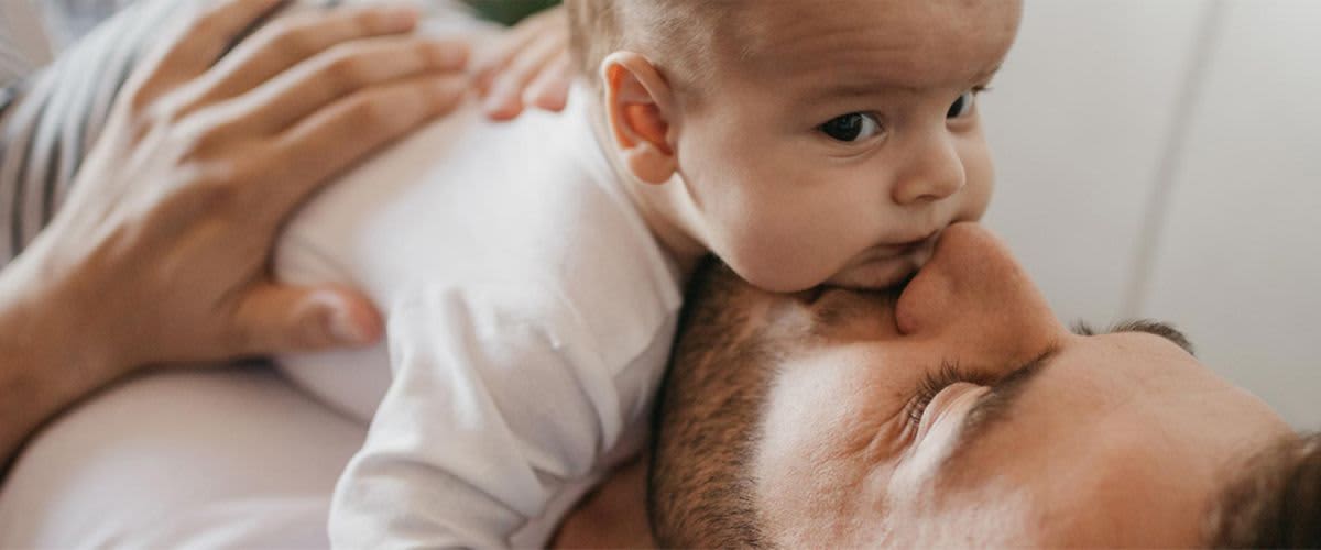 Baby liegt auf Bauch des Vaters
