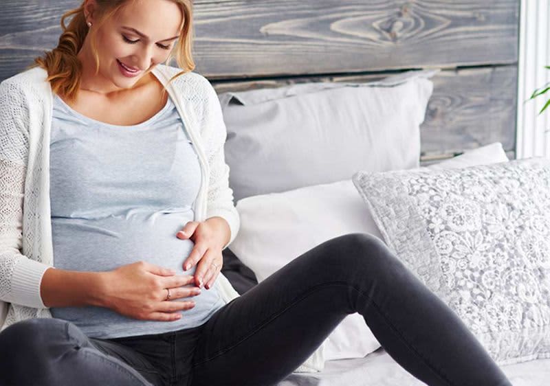 Schwangere Frau streichelt ihren Bauch