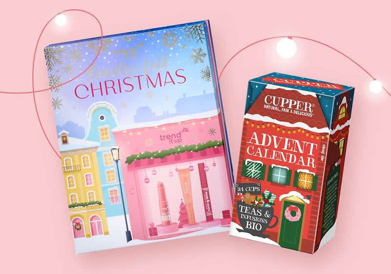 Zwei Produktverpackungen vor einem rosa Hintergrund, links eine große Box mit der Aufschrift Beauty Full Christmas und trend IT UP in einem winterlichen Stadtbild mit Schneeflocken und einem Schaufenster mit Kosmetikprodukten, rechts eine kleinere Box mit der Aufschrift CUPPER NATURAL, FAIR & DELICIOUS ADVENT CALENDAR und 24 CUPS TEAS & INFUSIONS BIO in einem festlichen Design mit einem grünen Dach und roten Wänden, beide Verpackungen sind von einer leuchtenden Lichterkette umgeben