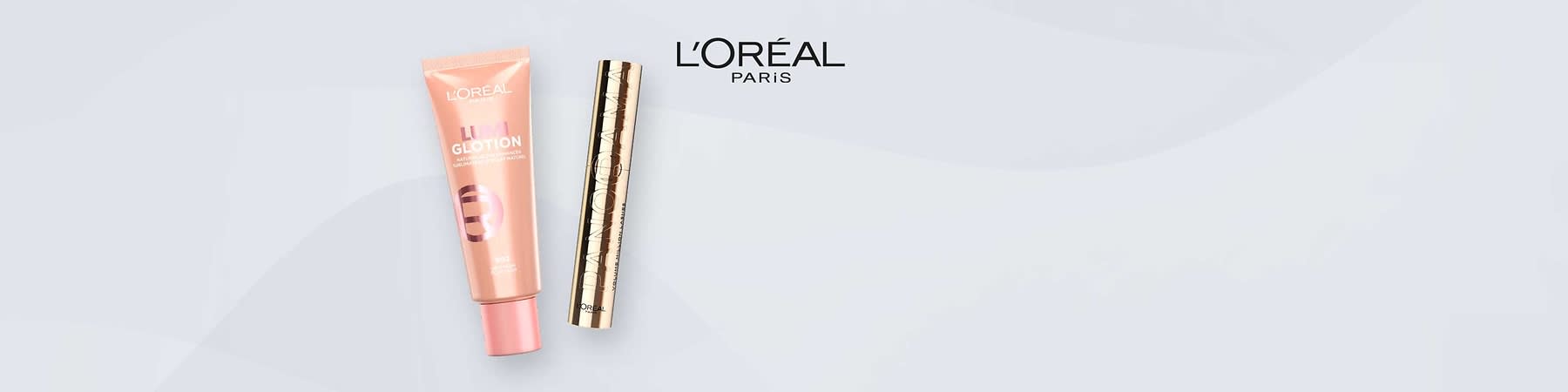 Eine rosa Tube mit der Aufschrift „Lumi Glotion“ und ein goldener Zylinder mit der Aufschrift „Paradise“ von L'Oréal Paris