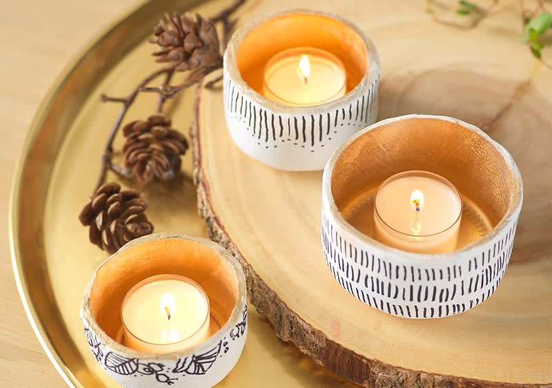 Drei Teelichter auf Holzscheibe