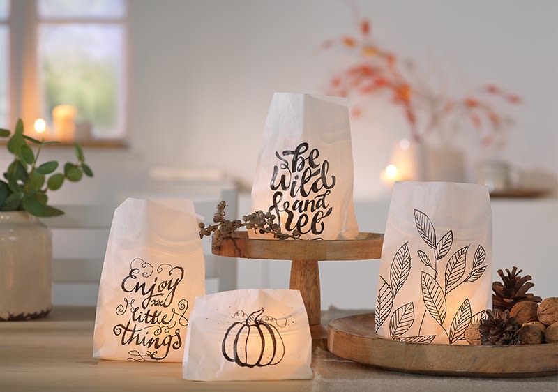 Vier dekorative Papierlichter mit Schriftzügen und Zeichnungen