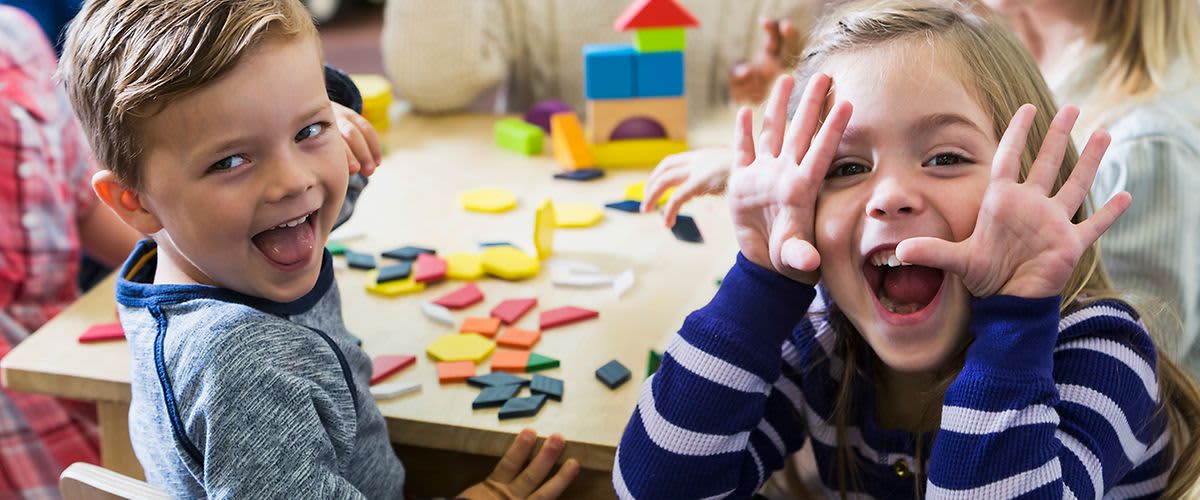 Kindergartenzeit genießen: fröhliche Kinder am Tisch