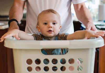Baby sitzt in Wäschekorb