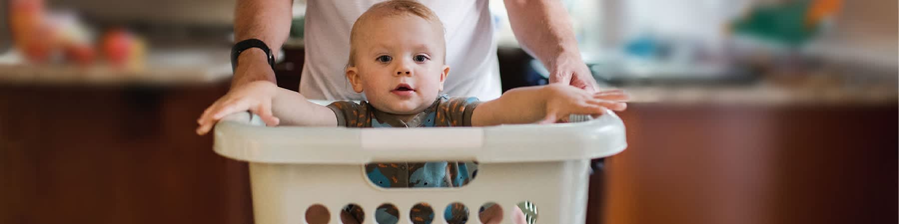 Baby sitzt in Wäschekorb