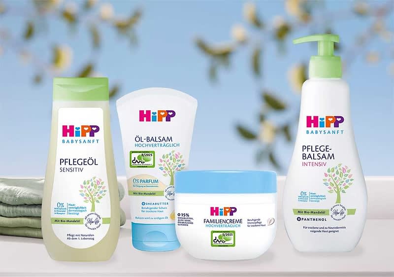 Vier HiPP Babysanft Pflegeprodukte nebeneinander: links eine grüne Flasche „Pflegeöl Sensitiv“, daneben ein weißes Tube „Öl-Balsam Hochverträglich“, vorne ein rundes blau-weißes Tiegel „Familiencreme Hochverträglich“, rechts eine Spenderflasche „Pflege-Balsam Intensiv“ mit Pumpkopf und Pflanzenmotiv
