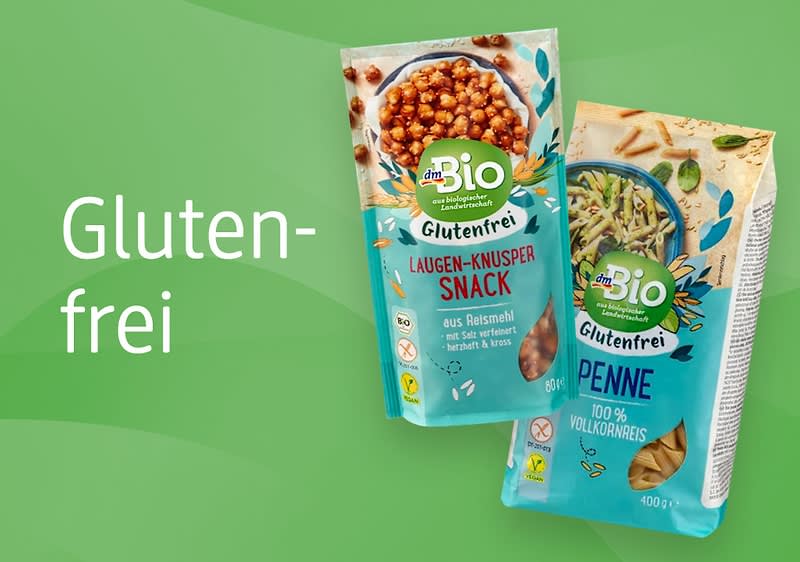 Zwei Produktverpackungen von dmBio, links ein Laugen-Knusper-Snack aus Reismehl mit braunen Knusperstücken, rechts glutenfreie Penne aus Vollkornreis mit grünen Kräutern, daneben der Text „Glutenfrei“ auf grünem Hintergrund