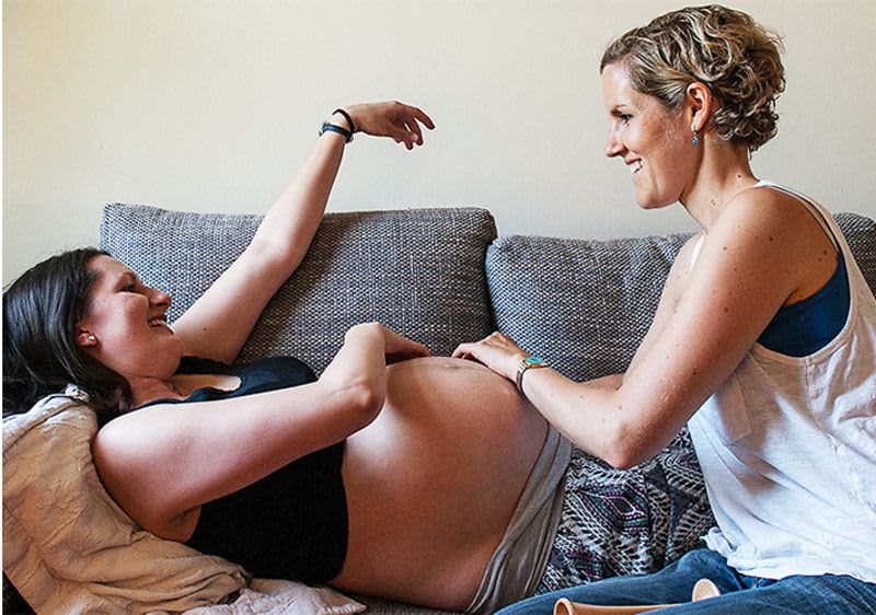 Hebamme tastet schwangerer Frau den Bauch ab