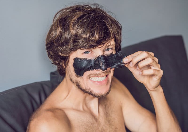 Mann zieht sich eine Gesichtsmaske ab