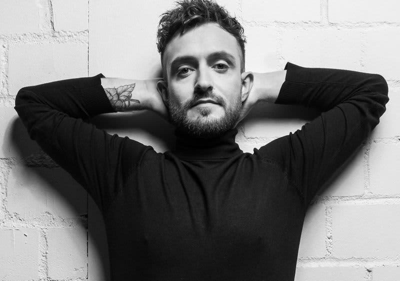 Mann mit Tattoo am Unterarm, Bart und gepflegter Haut