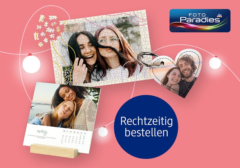 Bedruckte Fotogeschenke von Fotoparadies und daneben Großmutter und Enkelin freuen sich über Weihnachtsgeschenk