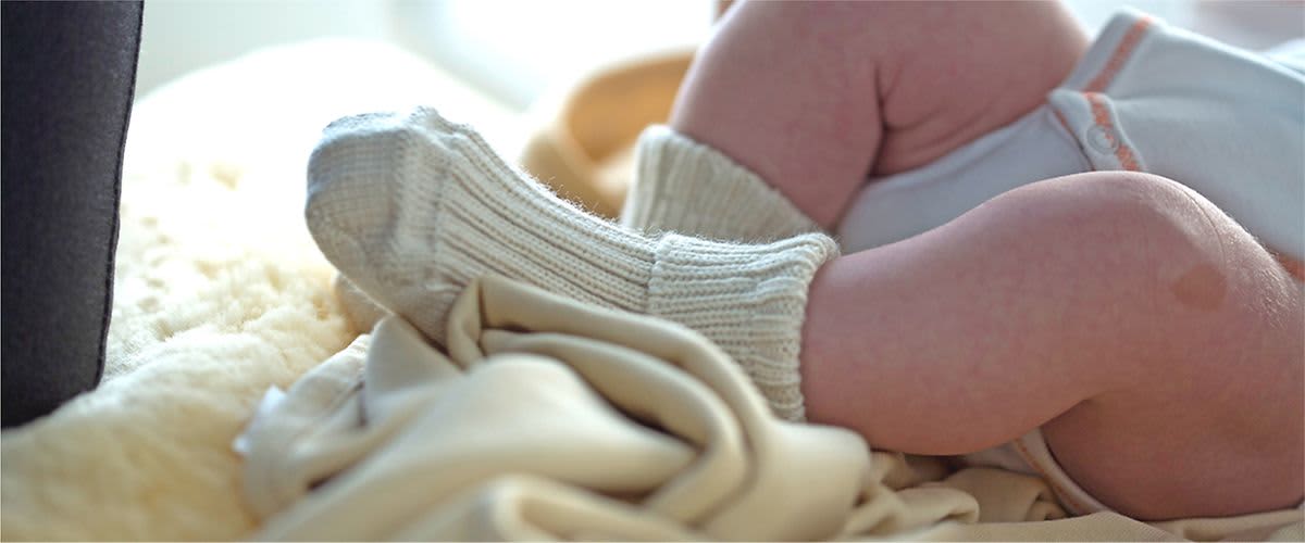Baby mit Wollsocken an den Füßen