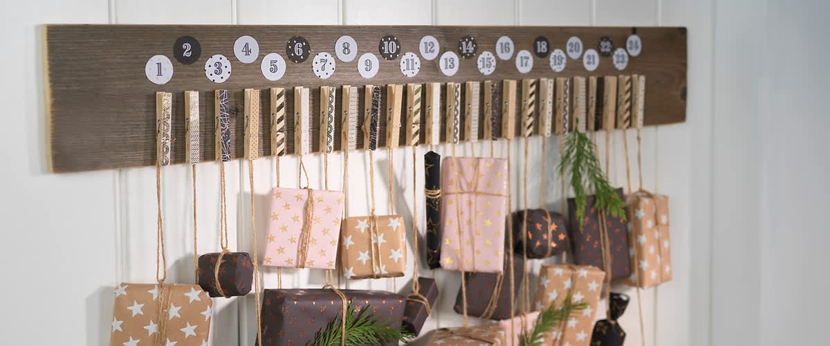 Adventskalender mit verzierten Holzklammern