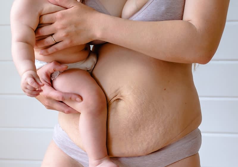 Mutter hat ihr Baby auf der Brust liegen.