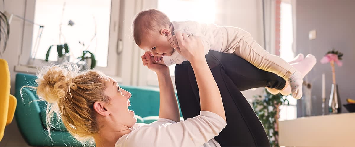 Frau bei Mama-Baby-Yoga mit ihrem Kind