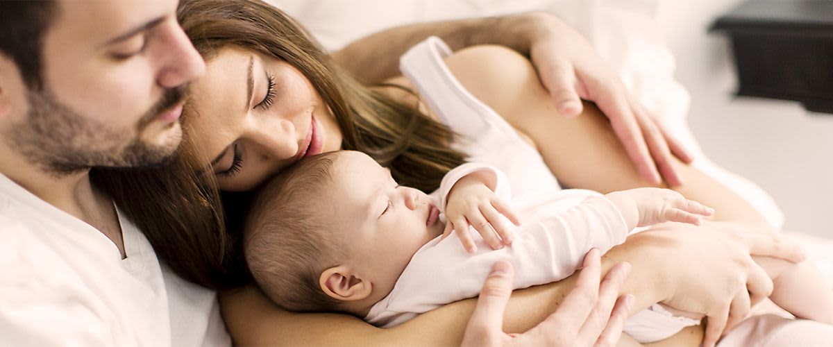Vater, Mutter und Baby kuscheln